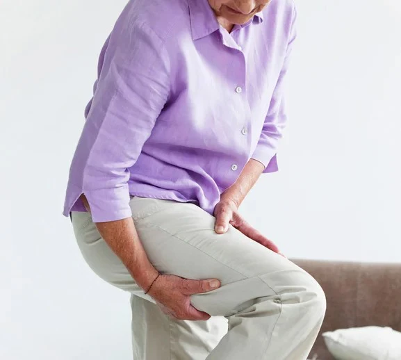 A woman with sciatic pain holding her leg